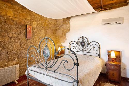 1 dormitorio con cama y pared de piedra en Casa Rural Pepita La De Las Flores, en Tejeda