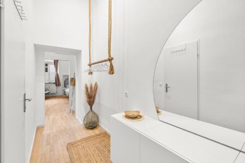 Habitación blanca con espejo y pasillo en The BoHo Loft VIE, en Viena