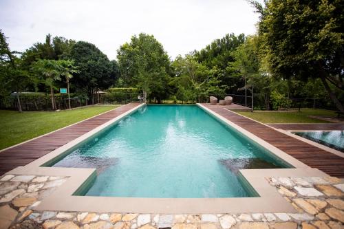 a swimming pool in a backyard with a wooden deck at Kalu's Hideaway Udawalawe in Udawalawe