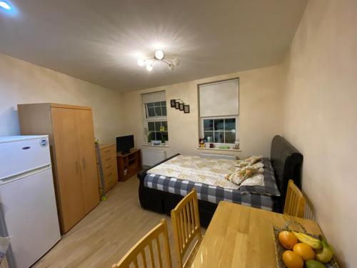 a room with a bed and a table and a kitchen at Stefi apartment room in Edgware