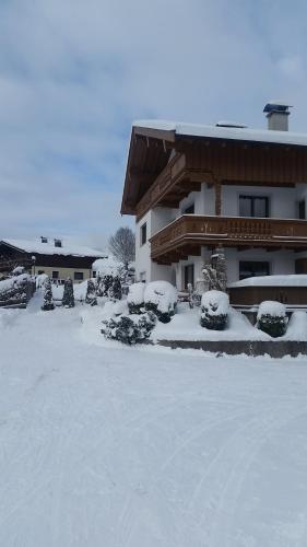 a building with snow on the ground in front of it at Haus Barbara in Waidring