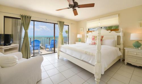 Pines & Palms Resort في إسلامورادا: غرفة نوم مع سرير وشرفه مع المحيط