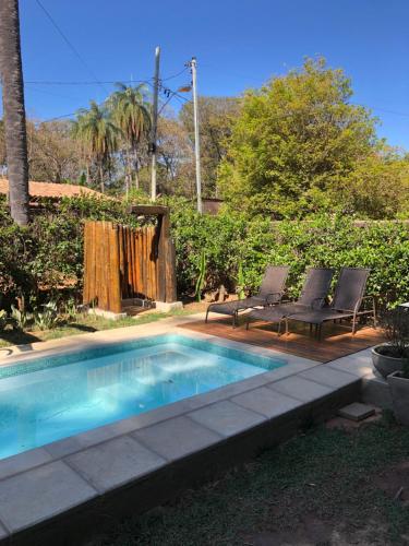 a small swimming pool with two chairs next to at Casa da Rê in Serra do Cipo