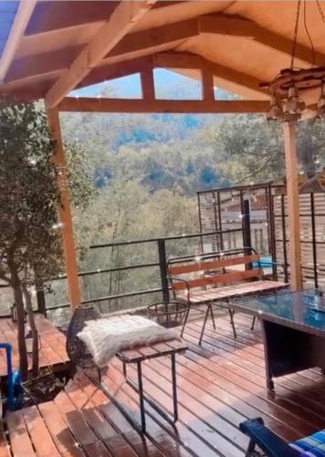 a deck with a table and benches on it at Los queñes Country House in Los Queñes
