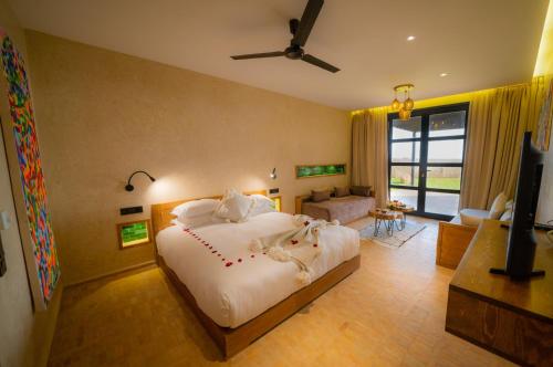 a bedroom with a large bed and a living room at BABERRIH Hôtel Hospitality Palaces & Resorts in Essaouira