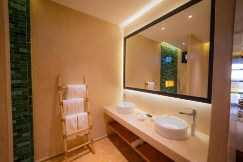 a bathroom with a sink and a large mirror at BABERRIH Hôtel Hospitality Palaces & Resorts in Essaouira