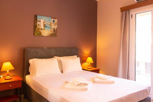 1 dormitorio con 1 cama con 2 toallas en Apagio Apartments en Mikros Gialos