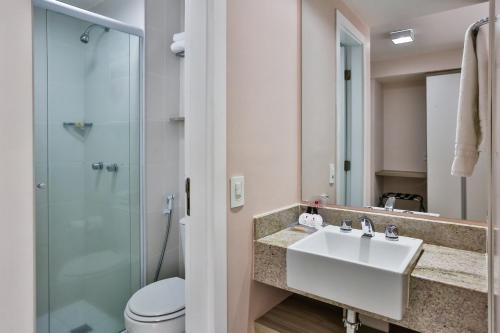 a bathroom with a sink and a shower at Ramada Hotel & Suites Campos Pelinca in Campos dos Goytacazes