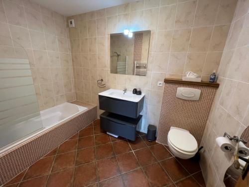 une salle de bain avec une baignoire, un lavabo et des toilettes dans l'établissement Lake Noble, à Saint-Germain-lʼAiguiller