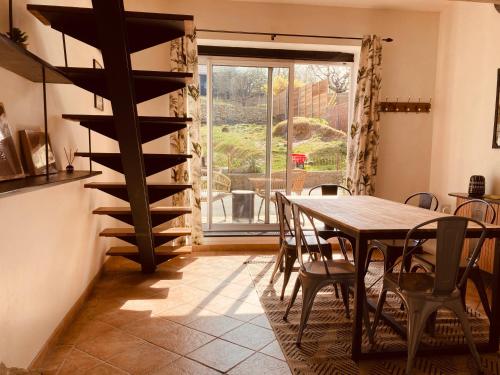 une salle à manger avec une table en bois et une cave à vin en spirale dans l'établissement Maison en pierre de70 m2 au cœur d’un hameau, à Seyssel