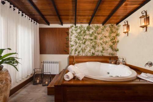a bathroom with a bath tub with a towel at Hotel Vivenda dos Sonhos in Gramado