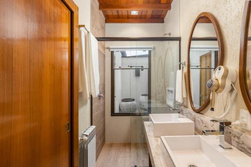 a bathroom with two sinks and a mirror at Hotel Vivenda dos Sonhos in Gramado