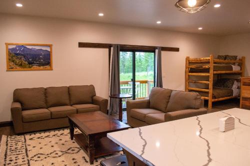 a living room with two couches and a table at Glacier Homestead in Coram