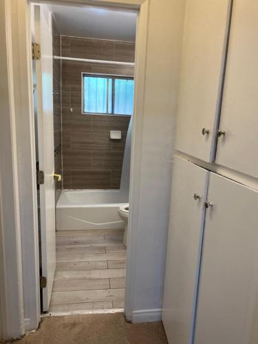 a bathroom with a tub and a toilet and a window at Amazing 1bd apartment with big office in Los Angeles