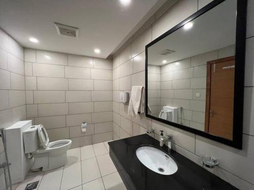 W łazience znajduje się umywalka, toaleta i lustro. w obiekcie *Designer’s Luxurious 1BHK at Top Location of Twin Cities!! w mieście Rawalpindi