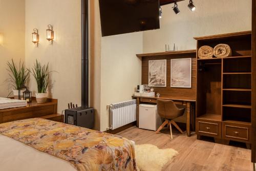 a bedroom with a bed and a desk with a computer at Hotel Vivenda dos Sonhos in Gramado