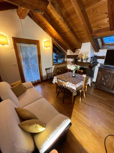 a living room with a couch and a table at Chalet Blanc "La Mansarda" in Courmayeur