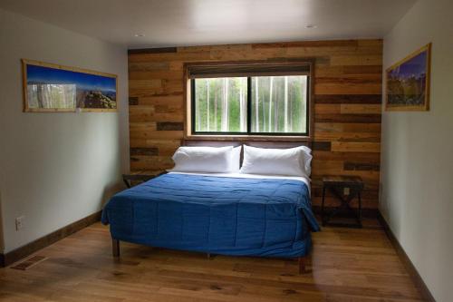 a bedroom with a blue bed and a window at Glacier Homestead in Coram