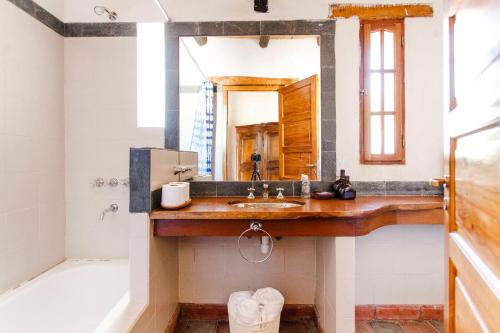 a bathroom with a sink and a tub and a mirror at Estancia Rio de Arena 