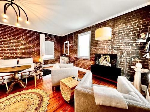 a living room with a brick wall at Be Our Gaston's "The Garden of Good" in Savannah
