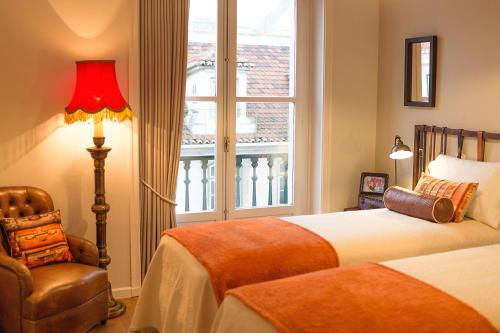 een slaapkamer met een bed, een stoel en een raam bij Unique Design Apartments in Lissabon