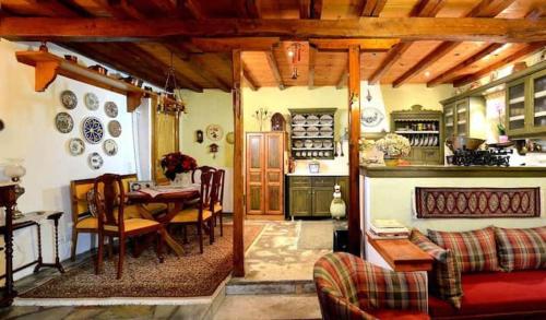 een woonkamer met een tafel en een eetkamer bij Archontiko Stafylopati in Makrinítsa