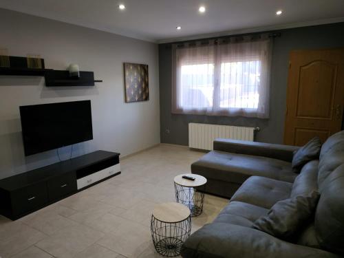a living room with a couch and a flat screen tv at Casa vacacional Lavernia in Cabanes