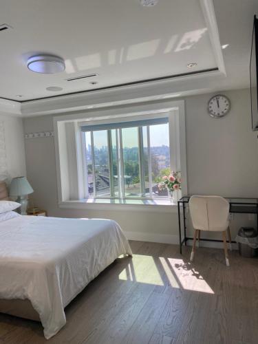 1 dormitorio con cama y ventana grande en Six minutes to Rupert station en Vancouver
