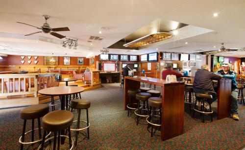 a bar in a restaurant with people sitting at the counter at Wilsonton Hotel Toowoomba in Toowoomba