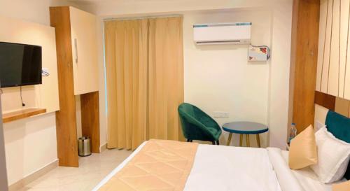 a hotel room with a bed and a green chair at City View With Garden -5 Mins Walk From GOLDEN TEMPLE in Amritsar
