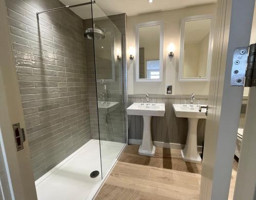 a bathroom with two sinks and a glass shower at Walcot Yard, Bath in Bath