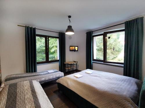 een slaapkamer met twee bedden en twee ramen bij Willa CIS in Karpacz
