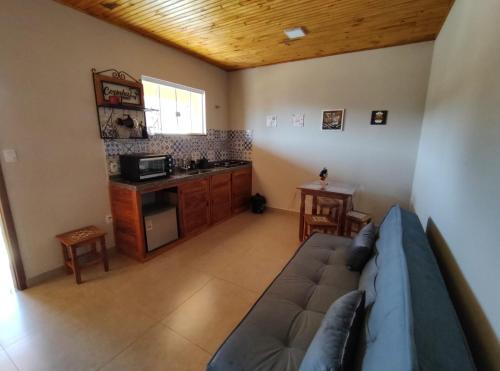 a living room with a couch and a kitchen at Flat dos Bandeirantes in Tiradentes