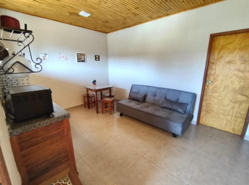 uma sala de estar com um sofá e uma mesa em Flat dos Bandeirantes em Tiradentes