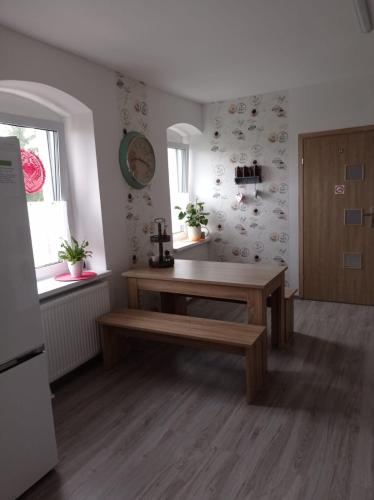 a kitchen with a wooden table and a bench at Dom Mili in Henryków Lubański