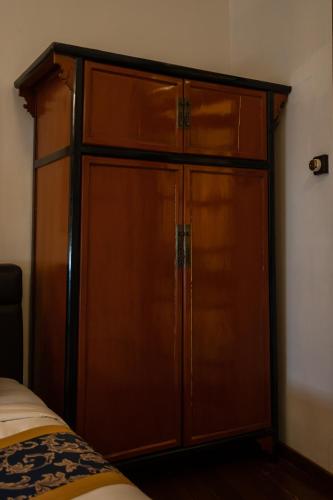 a large wooden closet in a room with a bed at Hotel Penaga in George Town