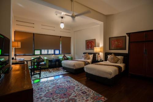 a hotel room with two beds and a living room at Hotel Penaga in George Town