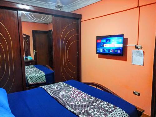 a bedroom with a bed and a tv on the wall at Fayrouzat Smoha near the city with open view in Alexandria