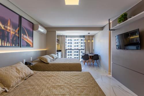a hotel room with two beds and a tv at Apart Hotel Centro de Brasília in Brasilia