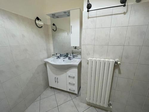 baño con lavabo, espejo y radiador en Appartamento “Liberty” en Paderno Dugnano