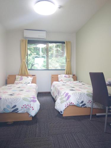 1 dormitorio con 2 camas, ventana y silla en Cate no mori - Vacation STAY 20997v en Shime
