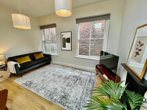 een woonkamer met een bank en een tv bij Micklegate Apartment in York