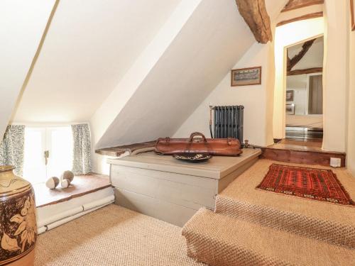 a attic room with a staircase with a bench and a mirror at Ona Ash in Penrith