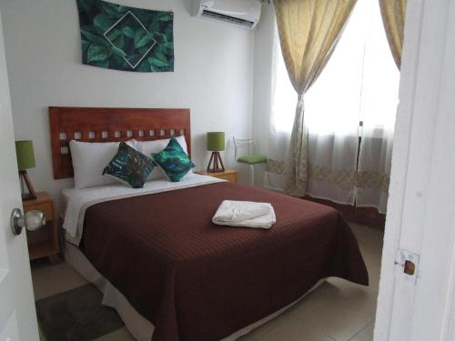 Un dormitorio con una cama grande y una ventana en Preciosa Casa Palmera en Cuernavaca con Alberca, Wifi, TV y Cocina Para fin de semana, descanso, vacaciones o Home office en Emiliano Zapata