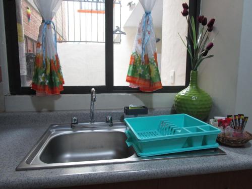 a kitchen sink with a blue tray on it at Preciosa Casa Palmera en Cuernavaca con Alberca, Wifi, TV y Cocina Para fin de semana, descanso, vacaciones o Home office in Emiliano Zapata