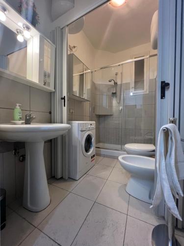 a bathroom with a sink and a washing machine at La Nova apartment in Naples