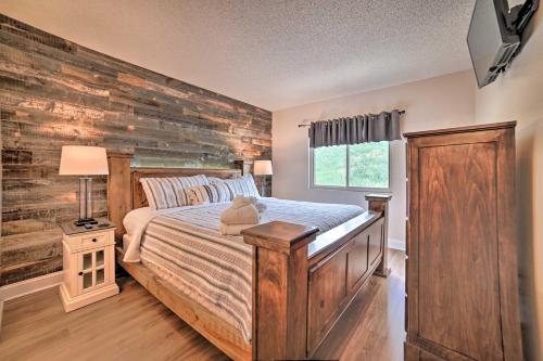 a bedroom with a bed and a wooden wall at Gatlinburg Condo with Smoky Views Walk to Town! in Gatlinburg
