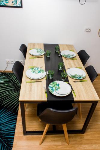 - une table en bois avec des chaises et des assiettes dans l'établissement F2 Duplex chez l'aventurière près Disneyland, à Roissy-en-Brie