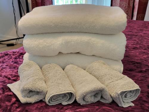 a stack of towels sitting on a bed at Hoomaikai Blessings in Keaau