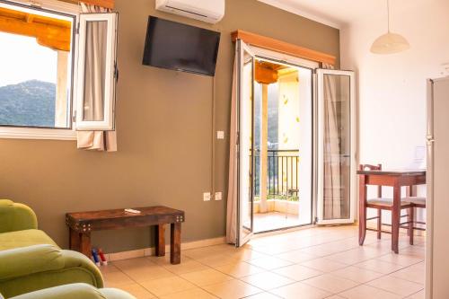 a living room with a couch and a tv at Apagio Apartments in Mikros Gialos